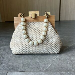 Braided clutch with versatile pearl straps and wooden detail